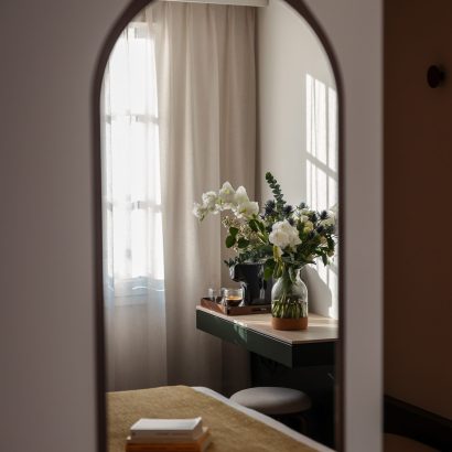 miroir avec vase et fleurs blanche d'une chambre - hôtel restaurant la rochelle